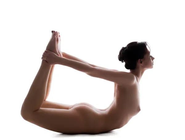 Гибкая голая женщина делает упражнения в студии — стоковое фото