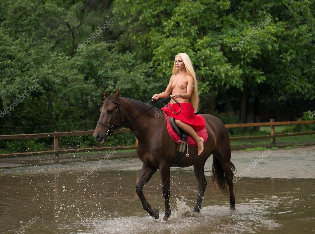 Chica desnuda en el jinete rojo a caballo 